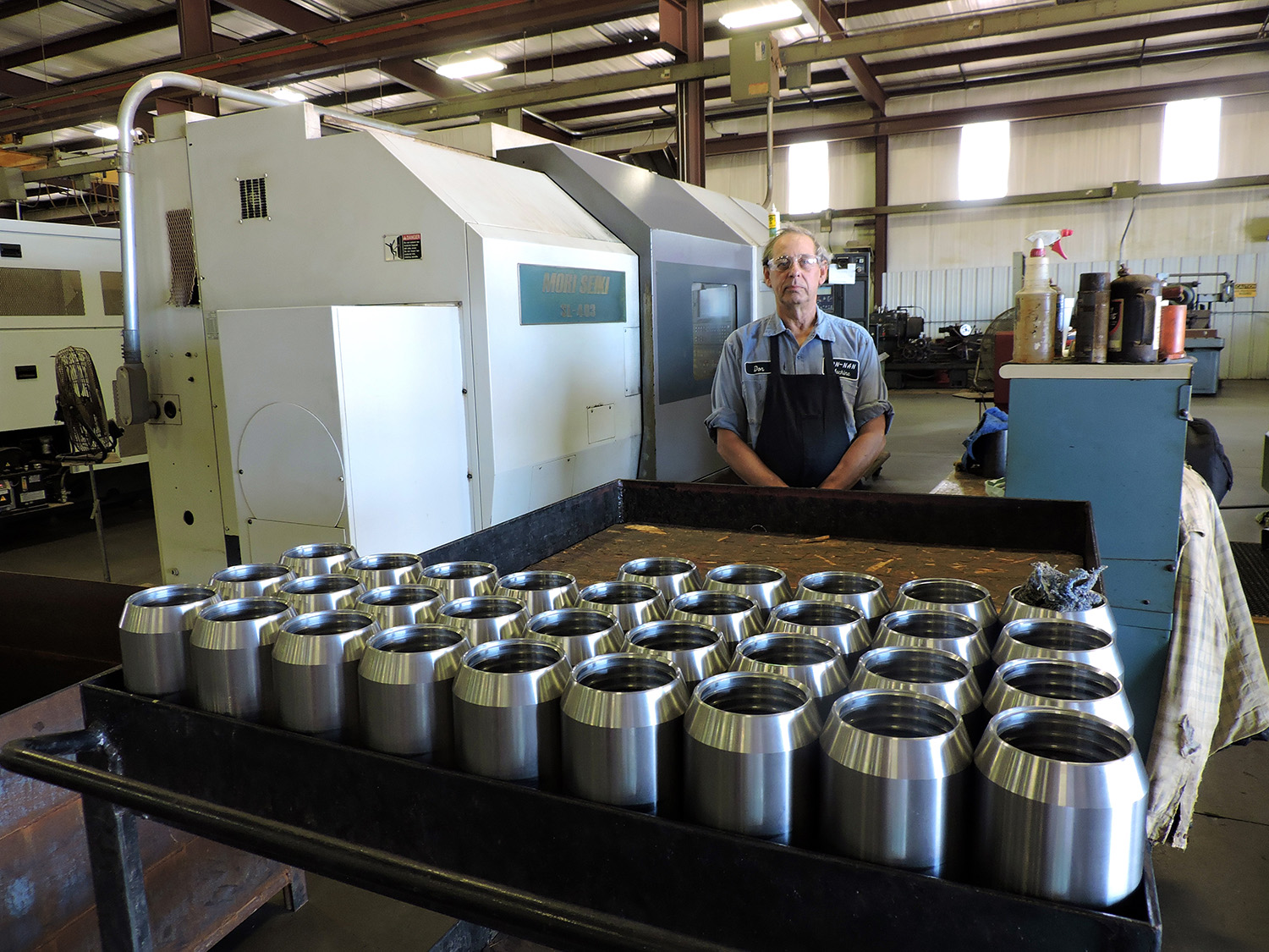 Don-Nan Pump and Supply machinist Don Moran stands behind a collection of Baker style lower cones. Moran deburrs the component at the Don-Nan manufacturing facility in Midland. 